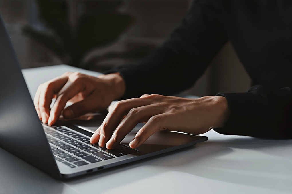 mãos a escrever num computador portátil