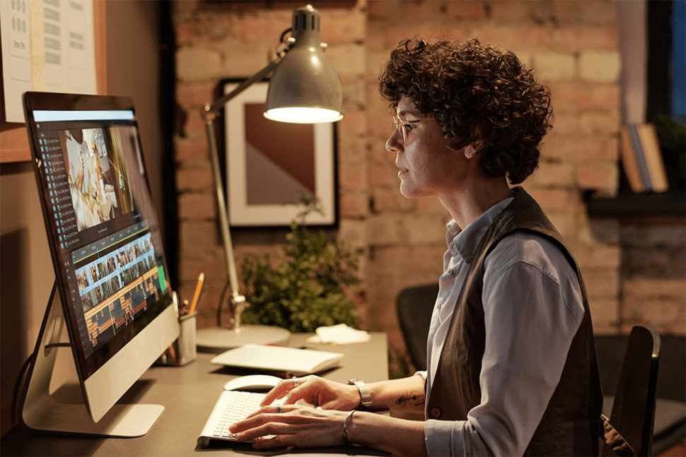 A lady is editing a video on a desktop computer