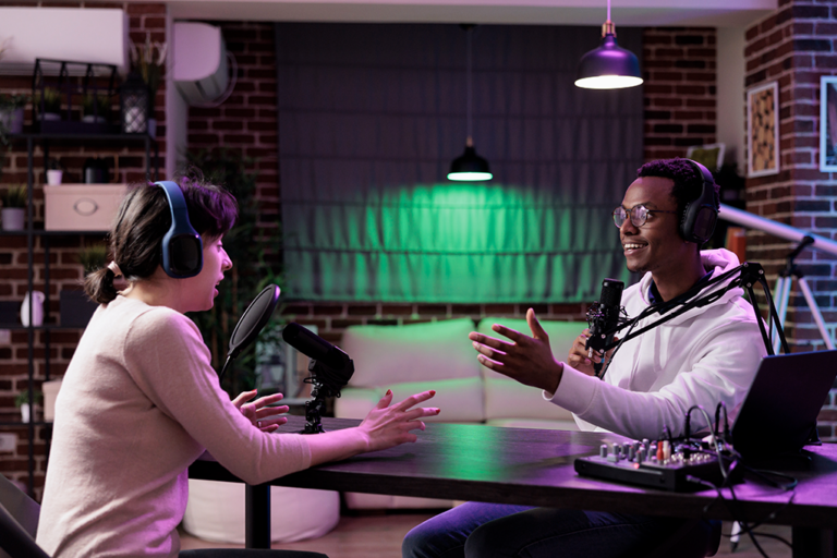 A couple is recording something using a microphone and headphones