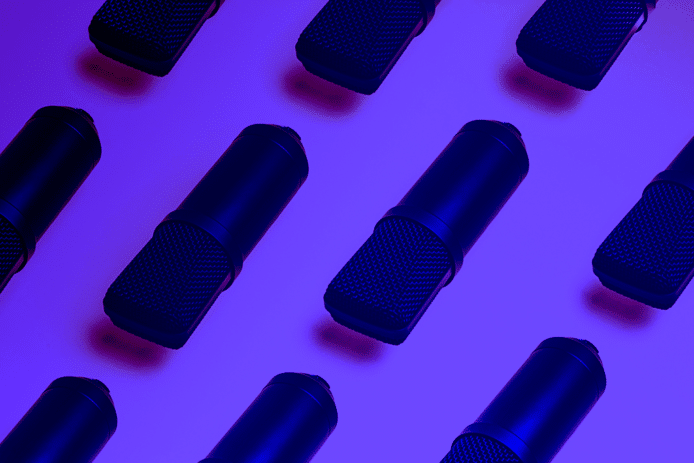 Vários microfones são colocados numa superfície branca com uma luz roxa a iluminá-los
