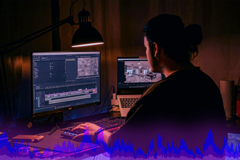 person looking at an audio file and video file on two separate laptops