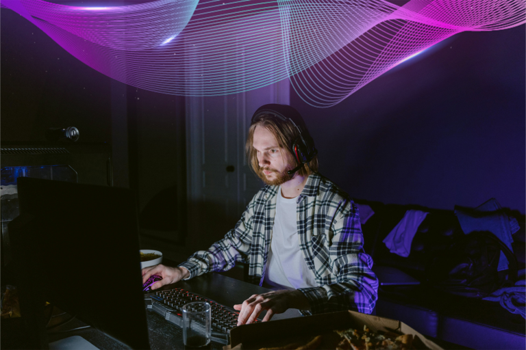 homme assis dans une chambre noire regardant un clavier