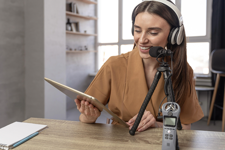 mujeres que graban un podcast y revisan una tableta