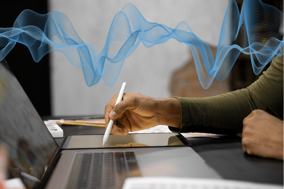 escribiendo a mano en una tableta mientras escucha un archivo en su portátil